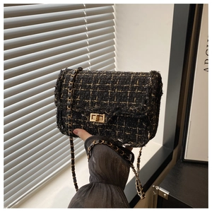 Close-up of vintage tweed crossbody bag with gold chain strap and metallic lock
