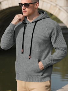 Detailaufnahme von grauem Kapuzenpullover mit Waffelstruktur und schwarzem Kordelzug