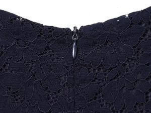 Macro shot of navy blue lace dress back detail showing invisible zipper and hollow mesh