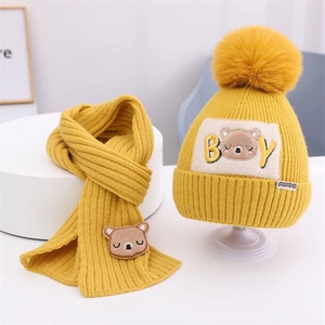 Detail von gelbem Strickmützen- und Schal-Set mit süßen schlafenden Bären-Stickereien