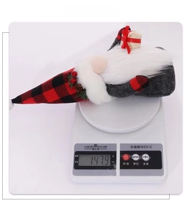 Weight display of Christmas gnome doll showing 147.9g on a digital scale for accuracy