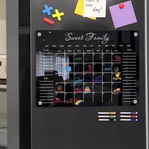 Detail of magnetic acrylic weekly planner with six colored dry erase markers on a fridge