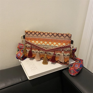 Detail of ethnic woven bag with colorful tassels and geometric patterned strap