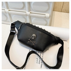 Close-up of black pebble leather waist bag featuring silver skull emblem and metal studs