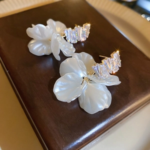 Detailed close-up of shell flower tassel earrings with zircons and gold-plated hardware