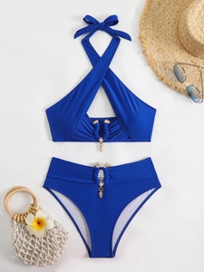 Detail of royal blue bikini set with metal pendants and elegant beach accessories