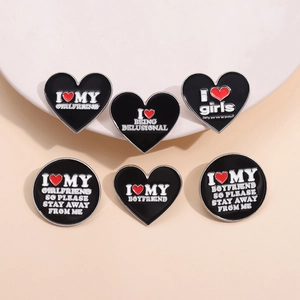 Set of 6 black heart enamel brooches with white text and red heart motifs on a beige background