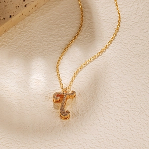 Macro view of 18K gold plated letter T pendant necklace with sparkling cubic zirconia inlay