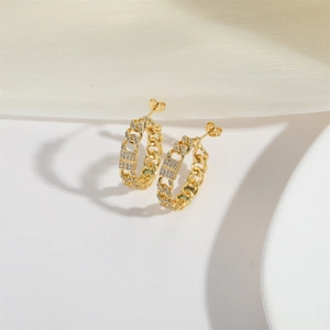 Macro shot of gold-plated chain-link earrings with pavé set zircon stones