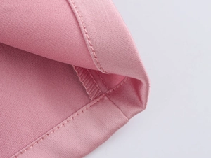 Gros plan détaillé du tissu textile rose montrant les coutures fines et la texture tissée