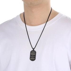 Detail of black military dog tag necklace with Dad Hero engraving worn by male model