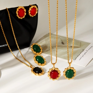 Close-up of vintage gold-toned jewelry set with vibrant red and green gemstone accents