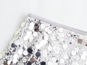 Detail of silver sequin mini skirt with grey satin waistband and metallic embroidery texture