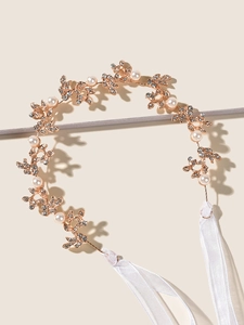 Detailed shot of golden alloy leaf bridal headband with handmade pearls and rhinestones