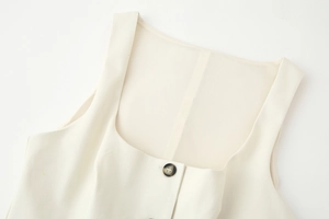 Detailed close-up of cream square neck vest showing textured fabric and front buttons