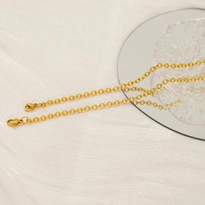 Luxurious gold titanium steel layered necklace on a white textured fabric background