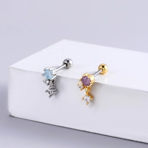 Macro detail of gold and silver steel earrings with blue and purple zircon stones