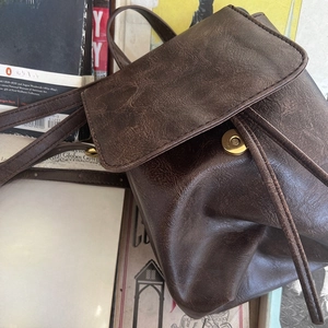 Dettaglio dello zaino vintage marrone con fibbia magnetica su uno sfondo retrò classico