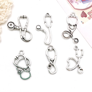 Macro view of six antique silver stethoscope pendants for DIY jewelry crafting and design