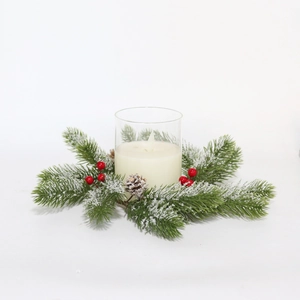 Detail of Christmas LED candle in glass holder with snowy pine needles and red berries