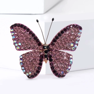 Detailed macro shot of a rhinestone butterfly brooch with purple crystals and gold base