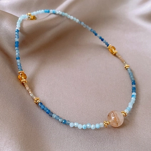 Macro detail of agate pearl crystal necklace with blue beads on champagne silk