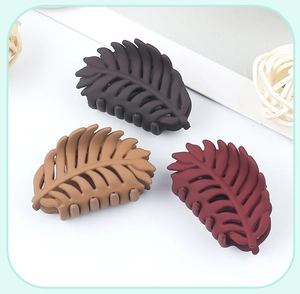 Detailed view of three matte leaf-shaped hair claws in dark, light, and reddish brown tones
