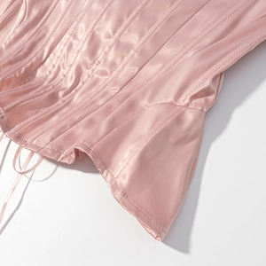 Detailed close-up of pink satin corset top showing luxury fabric and vertical bone stitching