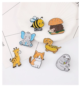 Group display of cartoon animal enamel pins including sloth, hedgehog and elephant
