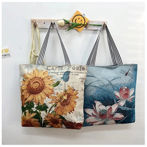 Detailed shot of sunflower and lotus art tote bags with striped handles on wooden hooks