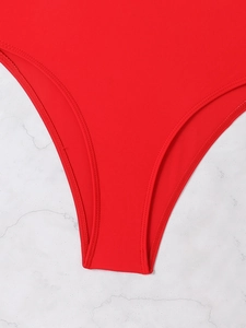 Detailed close-up of high-cut leg opening and double-needle stitching on red swimsuit