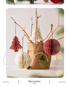 Dettaglio di ornamenti natalizi in carta a nido d'ape, albero e palla, crema e rosso