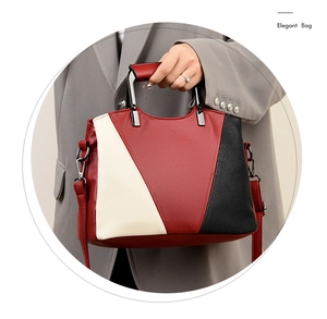 Detail of elegant tricolor tote bag with lychee texture leather and metal handle