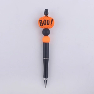 Detail of Halloween beaded pen with orange pumpkin topper and Boo text on white base