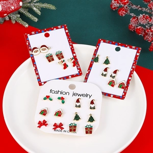 Christmas stud earrings set with Santa, trees and gift boxes on festive background