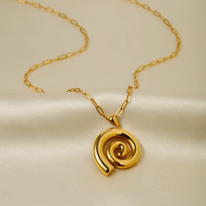 Macro detail of 18k gold plated stainless steel spiral pendant on a paperclip chain