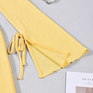 Gros plan détaillé sur le tissu en maille gaufrée jaune avec manches cloche à lacets