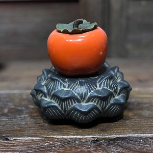 Detailed view ofpersimmon-shaped craft jar on a lotus petal base with a Zen aesthetic