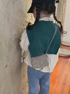 Detail of a sparkling silver rhinestone mini bag with a metal chain strap on a child