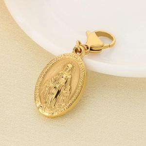 Macro shot of oval gold Miraculous Medal pendant with lobster clasp on beige texture
