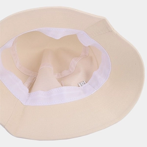 Vue intérieure du chapeau bob crème montrant le bandeau et l'étiquette d'entretien