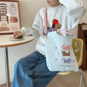 Detail of light blue quilted tote bag with cute animal embroidery and nice day text