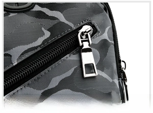 Gros plan sur la fermeture éclair en métal et le tissu Oxford camouflage du sac