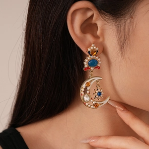 Vintage Baroque star and moon drop earrings with pearls and blue stones on female model