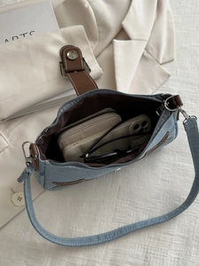 Internal view of blue denim shoulder bag showing space for phone and wallet