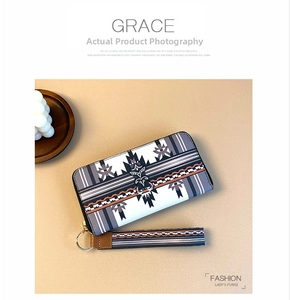 Detail view of long zipper wallet with ethnic geometric prints and detachable wrist strap