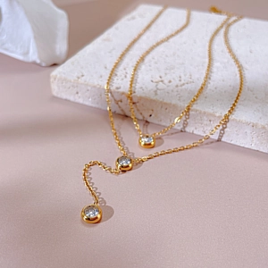Detail of 18K gold-plated stainless steel layered necklaces with zircon pendants