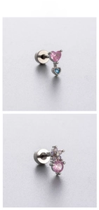 Λεπτομερής προβολή ροζ ζιργκόν σε σχήμα καρδιάς και μπλε λίθων σε ασημένια ατσάλινα σκουλαρίκια