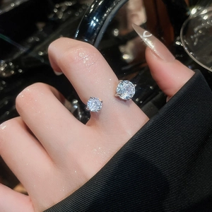 Vue macro d'une bague ouverte avec deux zircons brillants portée sur la main d'une femme