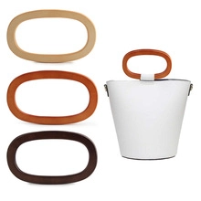 Detail showing three colors of oval wooden handbag handles on a white bucket bag
